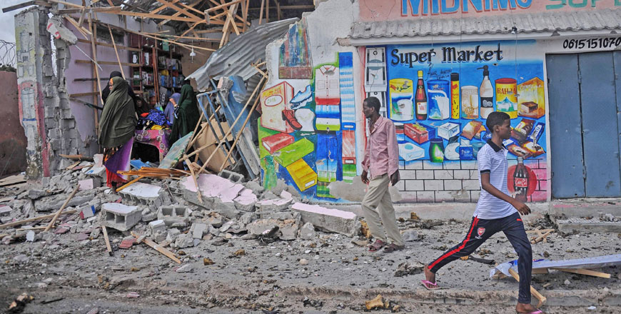 People stand amid rubble of destroyed shops in Mogadishu on Saturday (AFP photo)