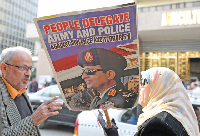 A supporter of Egyptian President Abdel Fattah Al Sisi holds a poster with his image in front of the National Election Authority in Cairo, Egypt , on Monday (AFP photo)