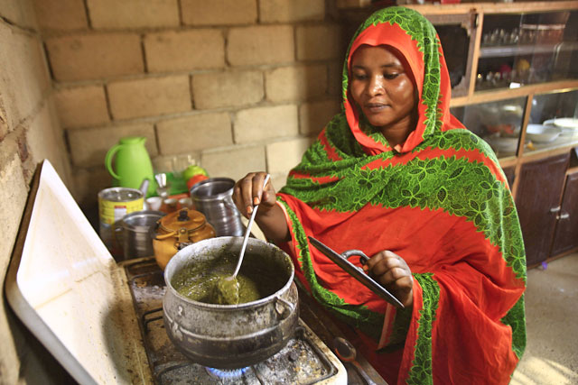 Shahinda Adel, wife of Sudanese engineer Ahmed Abdallah (unseen), stirs stew in a pot as she cooks in her kitchen in her home on the outskirts of the Sudanese capital’s twin city of Omdurman on Monday (AFP photo)