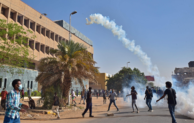 Demonstrators hurl tear gas canisters back at security forces amidst clashes in the centre of Sudan's capital Khartoum on Tuesday following protests against a deal that saw the civilian prime minister reinstated after the military coup in October (AFP photo)