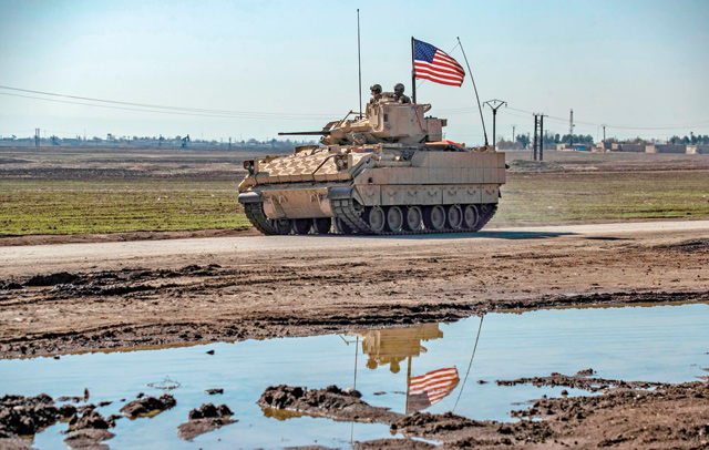 A US Bradley fighting vehicle patrols near oil production facilities in the countryside near Al Malikiyah (Derik) in Syria's northeastern Hasakeh province on Tuesday (AFP photo)