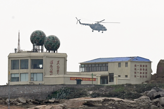 In this photo taken on April 7, a Chinese helicopter flies over a military base in Pingtan island, in China's southeast Fujian province (AFP photo)
