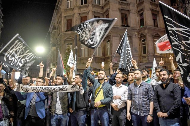 Protesters wave banners and flags featuring the Shahada (the Islamic creed stating a belief in one god and the acceptance that Mohammed was God's prophet) as they take part in a protest at the Istikilal Avenue in Istanbul on Monday (AFP photo)