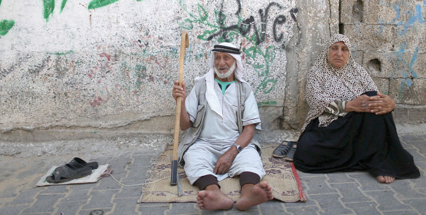 Palestinians sit outside their house at Khan Younis refugee camp in the southern Gaza Strip on Wednesday (Reuters photo)