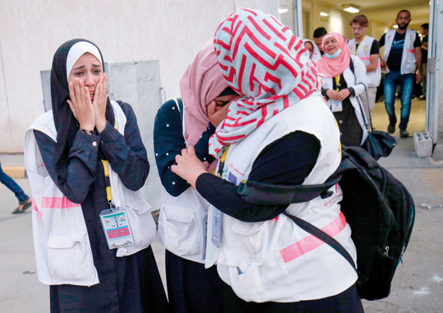 Palestinian paramedics mourn over the killing of their colleague Razan Al Najjar by Israeli forces outside Khan Yunis Hospital in the southern Gaza Strip, on Friday (AFP photo)