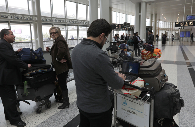 A Syrian passenger travelling to the United States through Amman types on his laptop before entering Beirut International Airport’s departure lounge on Wednesday (AFP photo)