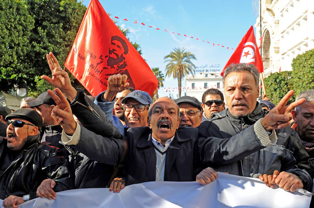 Tunisian workers shout slogans against the government in front of the Tunisian General Labour Union headquarters in Tunis, as they mark the seventh anniversary since the uprising that launched the Arab Spring, on Sunday (AFP photo)