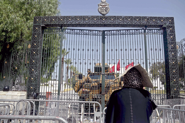A Tunisian woman looks at the army-barricaded parliament building in the capital Tunis on July 26, after the president dismissed the prime minister and ordered parliament closed for 30 days (AFP photo)