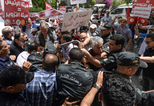 Tunisian labour party spokesman Hamma Hammami (centre) is among demonstrators blocked by the police as they headed towards the headquarters of the electoral authority ISIE, during a rally against their president, in the capital Tunis, on Saturday (AFP photo)