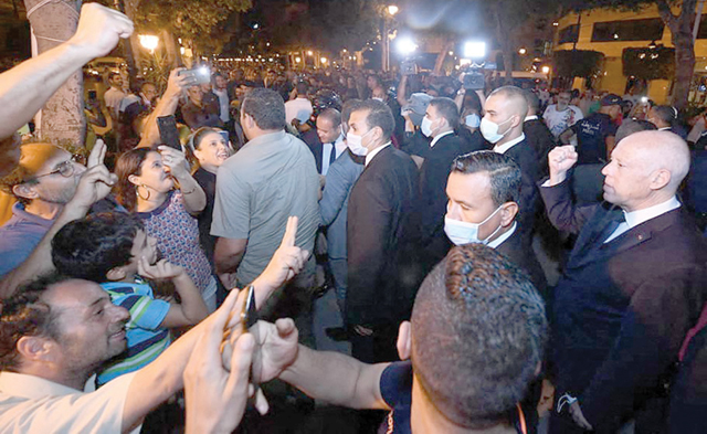 This handout photo provided by the Tunisian Presidency Facebook Page on Sunday shows Tunisian President Kais Saied (right) greeting people as he walks in Tunis's central Habib Bourguiba Avenue (AFP photo)