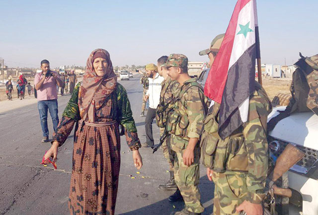 This handout photo released by the official Syrian Arab News Agency on Monday shows Syrians welcoming their country's army at the western entrance of the town of Tall Tamr in the countryside of Syria's northeastern Hasakeh province (AFP photo)