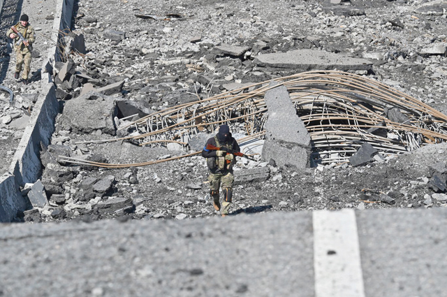 An Ukrainian serviceman walks accross a destroyed bridge in the town of Borodianka, northwest of Kyiv, on Monday (AFP photo)