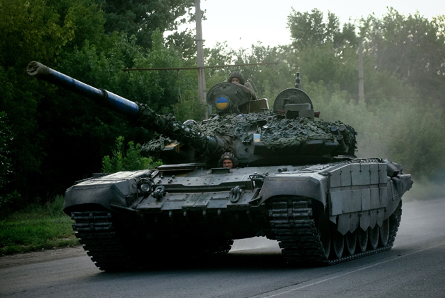 Ukrainian soldiers ride a tank on a road in the Donetsk region on Saturday, amid the Russian military invasion of Ukraine (AFP photo)