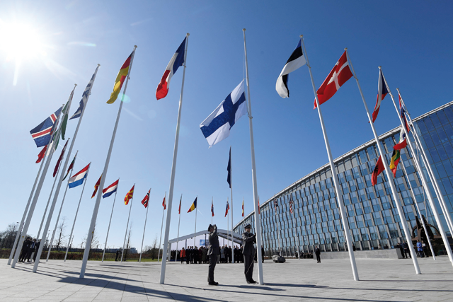  Finnish military personnel install the Finnish national flag at the NATO headquarters in Brussels on Tuesday (AFP photo)