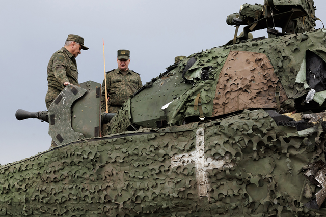 This handout photograph released by the Russian Defence Ministry's press service on Friday, shows Russia's Defence Minister Sergei Shoigu (left) getting on a captured Swedish armoured vehicle CV90 while inspecting a command post of the Central Military Unit in an undisclosed location in Ukraine (AFP photo)