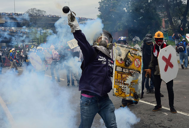   Opposition activists clash with riot police during a protest against Venezuelan President Nicolas Maduro in Caracas on Wednesday (AFP photo)