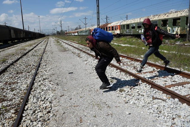 Habib (left), 22, from Algeria and a fellow migrant run to jump on a freight train in an effort to cross the Greek-Macedonian border without documents, in the northern city of Thessaloniki, Greece, April 6 (Reuters photo)