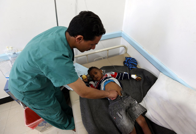 A Yemeni doctor checks a child suspected of being infected with cholera at a makeshift hospital in Sanaa on Friday (AFP photo)