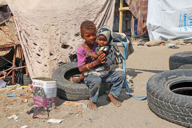 Displaced Yemeni children sit outside their makeshift shelter in an empty lot in the Yemeni coastal city of Hodeidah, on Thursday (AFP photo)