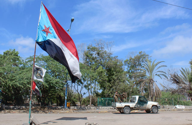 A file photo taken on April 26, shows fighters with Yemen's Southern Transitional Council (STC) driving a vehicle past a separatist flag (the old flag of South Yemen) as they deploy in the southern city of Aden (AFP photo)