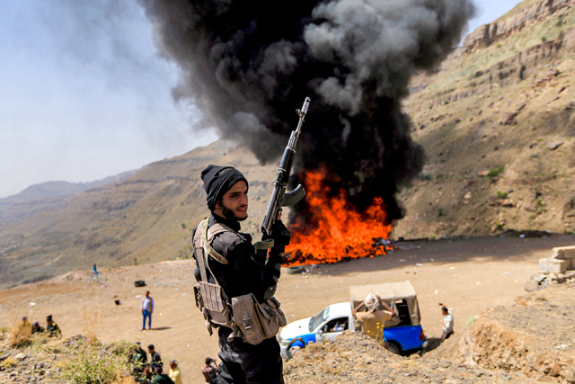 A member of security forces loyal to Yemen's Houthi rebels stands near a bonfire incinerating seized narcotic substances, in the Houthi-held capital on Saturday, the United Nations' designated 'International Day Against Drug Abuse and Illicit Trafficking' (AFP photo)