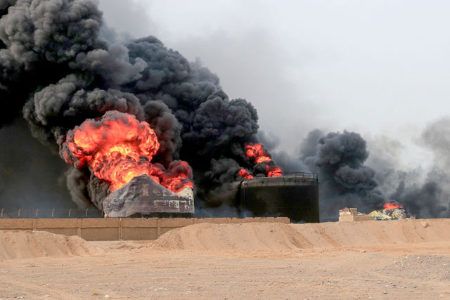 Thick smoke billows from a raging fire at oil storage tanks a day after Israeli strikes on the port of Yemen's Houthi-held city of Hodeida on Sunday (AFP photo)