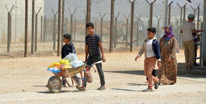 Syrian refugees carry food items at the Zaatari refugee camp, some 90km northeast of Amman (File photo)