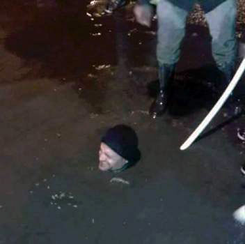 In this photo shared on social media networks over the weekend, Zarqa Minicipality worker Mohammad Saleh, neck-deep in water, attempts to open a manhole in the city, some 22km east of Amman, during the weekend 