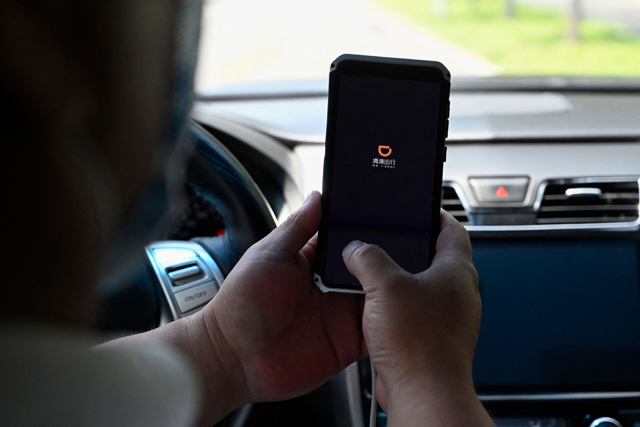 This file photo, taken on July 2, shows a driver opening the Didi Chuxing ride-hailing app on his smartphone in Beijing (AFP photo)