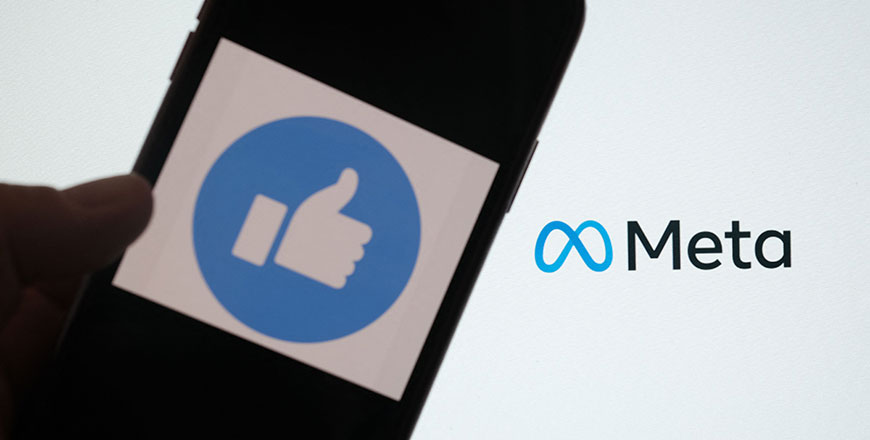 This file illustration photo taken in Los Angeles on October 28, 2021, shows a person using Facebook on a smartphone in front of a computer screen showing the META logo (AFP photo)