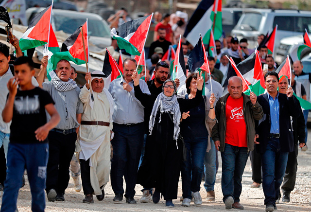 Palestinian protesters march with Palestinian flags during a demonstration at the Palestinian Bedouin village of Khan Al Ahmar, east of Jerusalem in the occupied West Bank and which Israel plans to demolish, on Friday  (AFP photo)