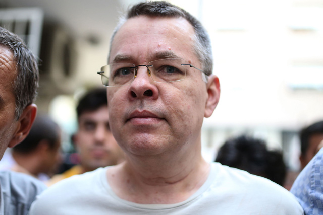 US pastor Andrew Craig Brunson is escorted by Turkish plainclothes police officers to his house in Izmir on July 25 (AFP photo)