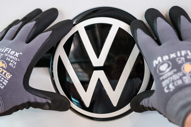 In this file photo taken on June 8, 2021,  a Volkswagen logo is seen at the assembly line for the Volkswagen ID 3 electric car of German carmaker Volkswagen, at the 'Glassy Manufactory' production site in Dresden, eastern Germany (AFP photo)