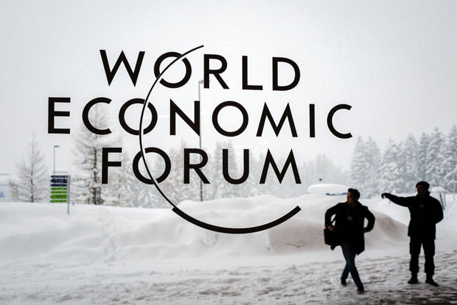 In this file photo taken on January 22, 2018, a security guard shows the way to a man outside of the Davos Congress Centre under snow ahead of the opening of the World Economic Forum 2018 annual meeting in Davos, eastern Switzerland (AFP file photo)