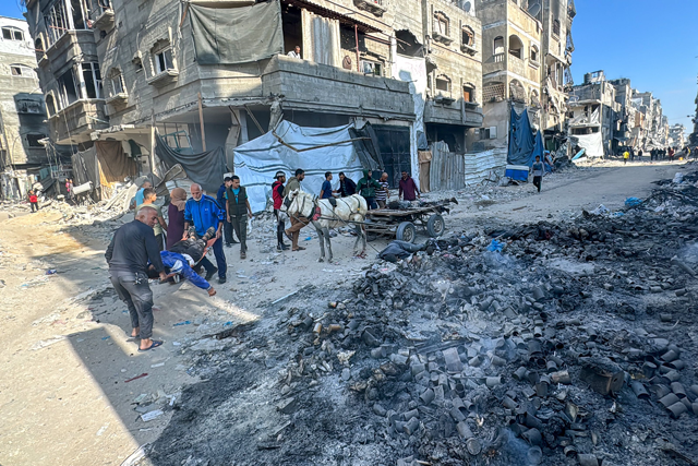 Palestinians carry bodies after an Israeli strike in Beit Lahia, northern Gaza Strip, on Wednesday (AFP photo)