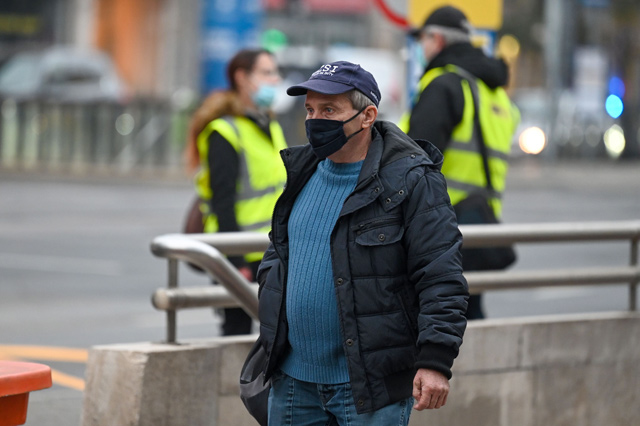 A man wearing a face mask waits for a bus in Budapest on Tuesday, hours before as a partial lockdown comes into force (AFP photo)