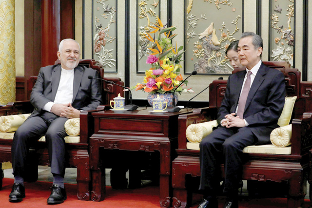 Iranian Foreign Minister Mohammad Javad Zarif (left) and his Chinese counterpart Wang Yi chat during their meeting at the Diaoyutai State Guesthouse in Beijing, China, on Tuesday  (Reuters photo)