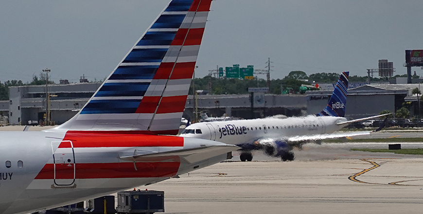 A JetBlue plane taxis to its gate past an American Airlines plane at the Fort Lauderdale-Hollywood International Airport in Fort Lauderdale, Florida, on July 16, 2020 (AFP photo)
