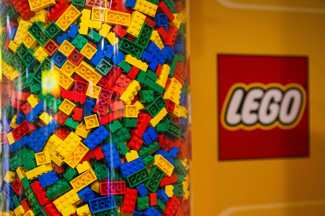 LEGO bricks are displayed next to a LEGO logo at a shop in the hotel LEGOLAND on November 29, 2022, in Billund, Denmark. Danish toy giant Lego said on Wednesday its net profit fell in the first half of the year but its market share grew as sales rose slightly (AFP photo)