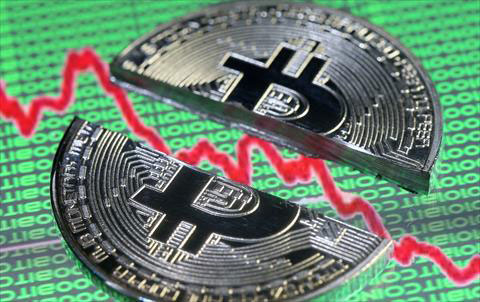 Broken representation of the Bitcoin virtual currency, placed on a monitor that displays stock graph and binary codes, are seen in this illustration photo on Thursday (Reuters photo)