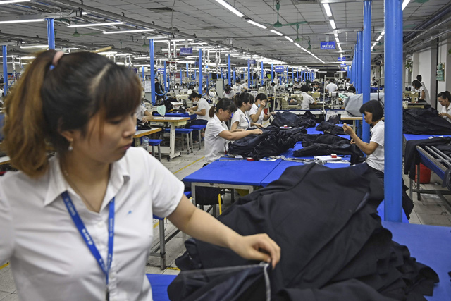 This photograph taken on May 24, 2019, shows garment factory workers making men’s suits in a factory in Hanoi (AFP photo)