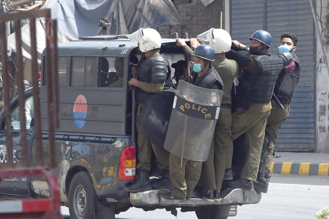 Policemen arrive at the site of a protest by the supporters of Tehreek-e-Labbaik Pakistan (TLP) Party along a blocked street during a demonstration after their leader was detained following his calls for the expulsion of the French ambassador, in Lahore, on Sunday (AFP photo)