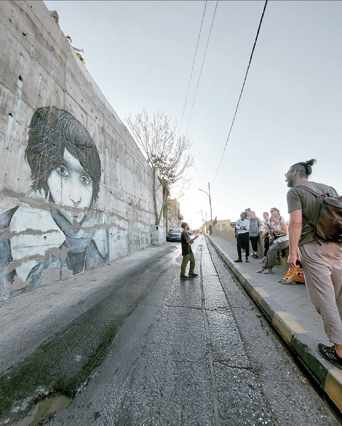 A tour guide is seen explaining street art to visitors during an Underground Amman Tour (Photo courtesy of Underground Amman Tour) 