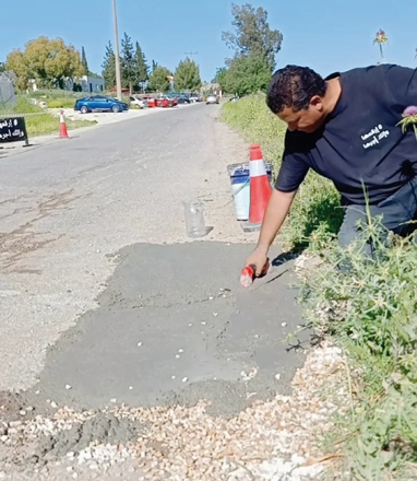A volunteer patches a pothole in a street in Irbid Governorate (Photo courtesy of Ahmad Omari)