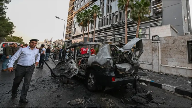 Syrian emergency and security services inspect the wreckage of a car that exploded in Damascus on October 21, 2024 (AFP photo)