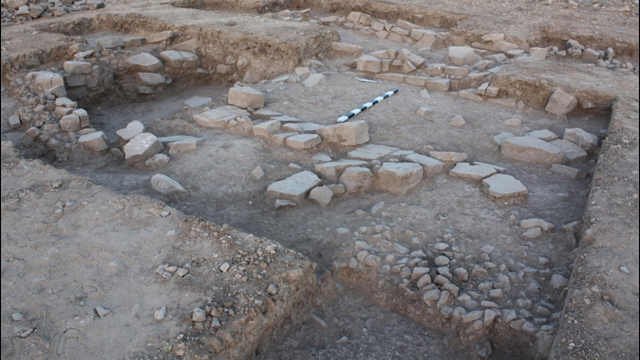 Remains of the structure at al-Khayran, with the cobblestone and flagstone surfaces visible in the foreground and the walls visible in the background (Photo courtesy of Matthew Kroot)