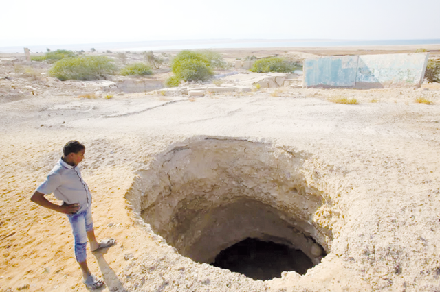 A villager looks at a sinkhole on the Dead Sea shore near Ghor Haditha, Jordan (AFP photo)