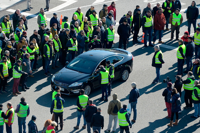 In this photo taken on January 22, 2019, taxi drivers, many wearing yellow vests, stop a Cabify driver during a strike in Barcelona to protest against regulations proposed by the authorities for tourism vehicles with chauffeur  (AFP file photo)