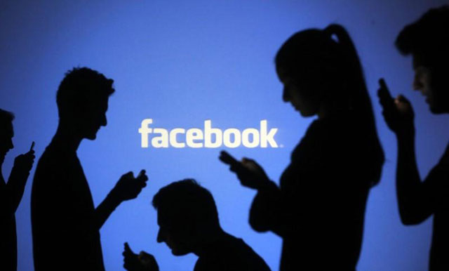 People are silhouetted as they pose with mobile devices in front of a screen projected with a Facebook logo, in this picture illustration taken in Zenica, on October 29, 2014  (Reuters file photo)