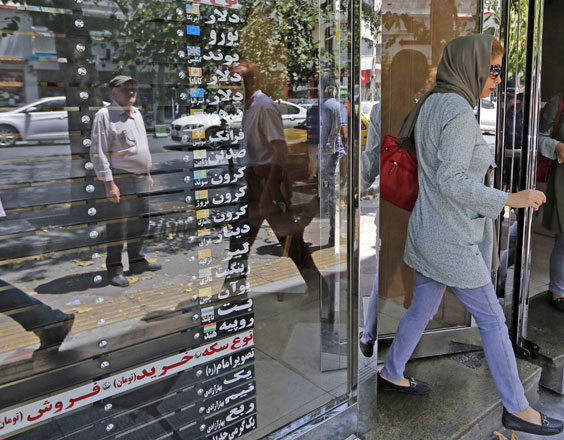 Iranians walk in front of a currency exchange shop in the Iranian capital Tehran on Wednesday (AFP photo)